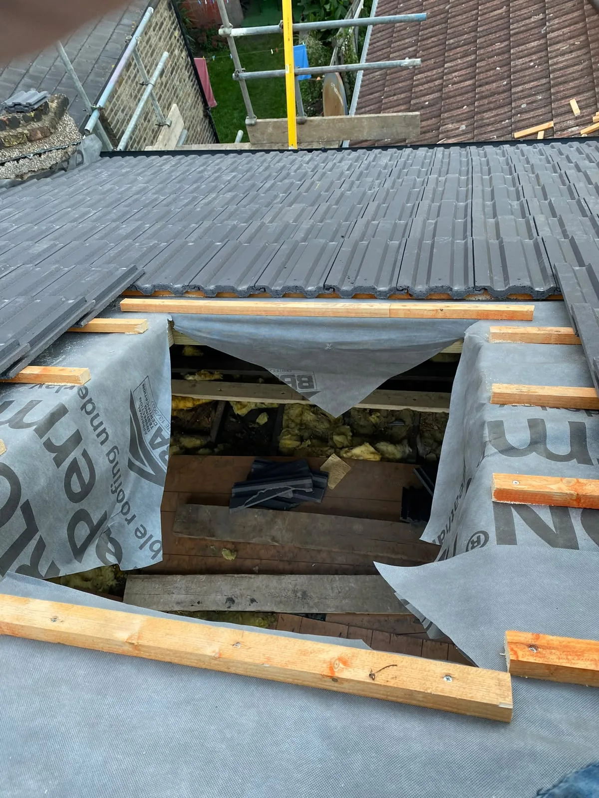 Roofing team installing tiles on a pitched roof